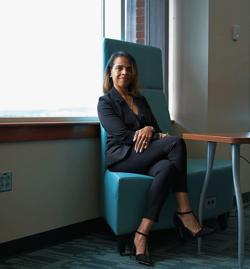 A woman sitting in a blue chair next to a table